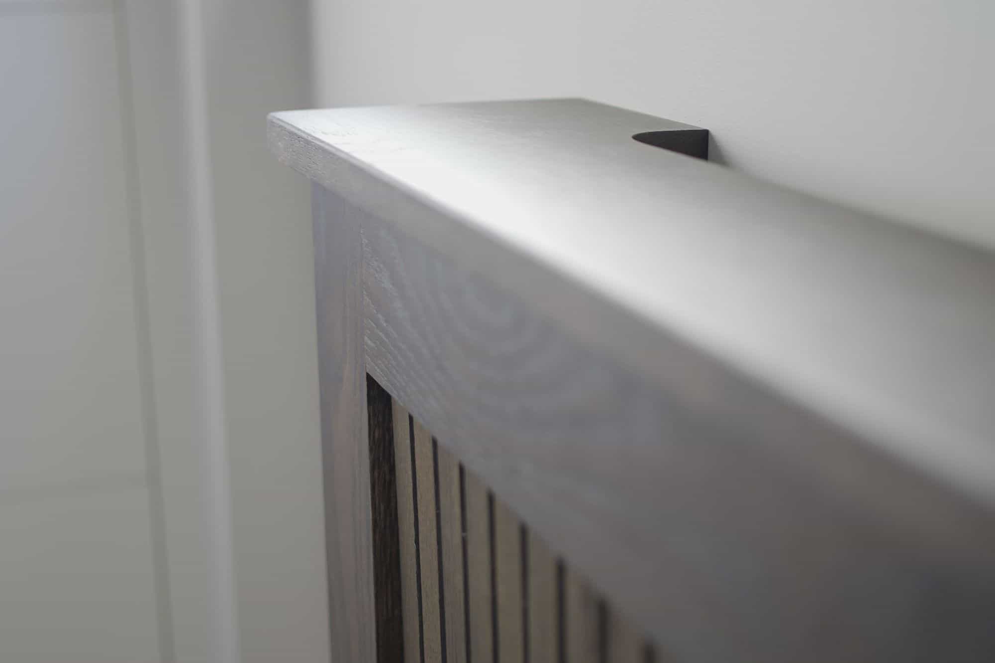 Close up of a mahogany radiator cover, showing the shelf and the grills